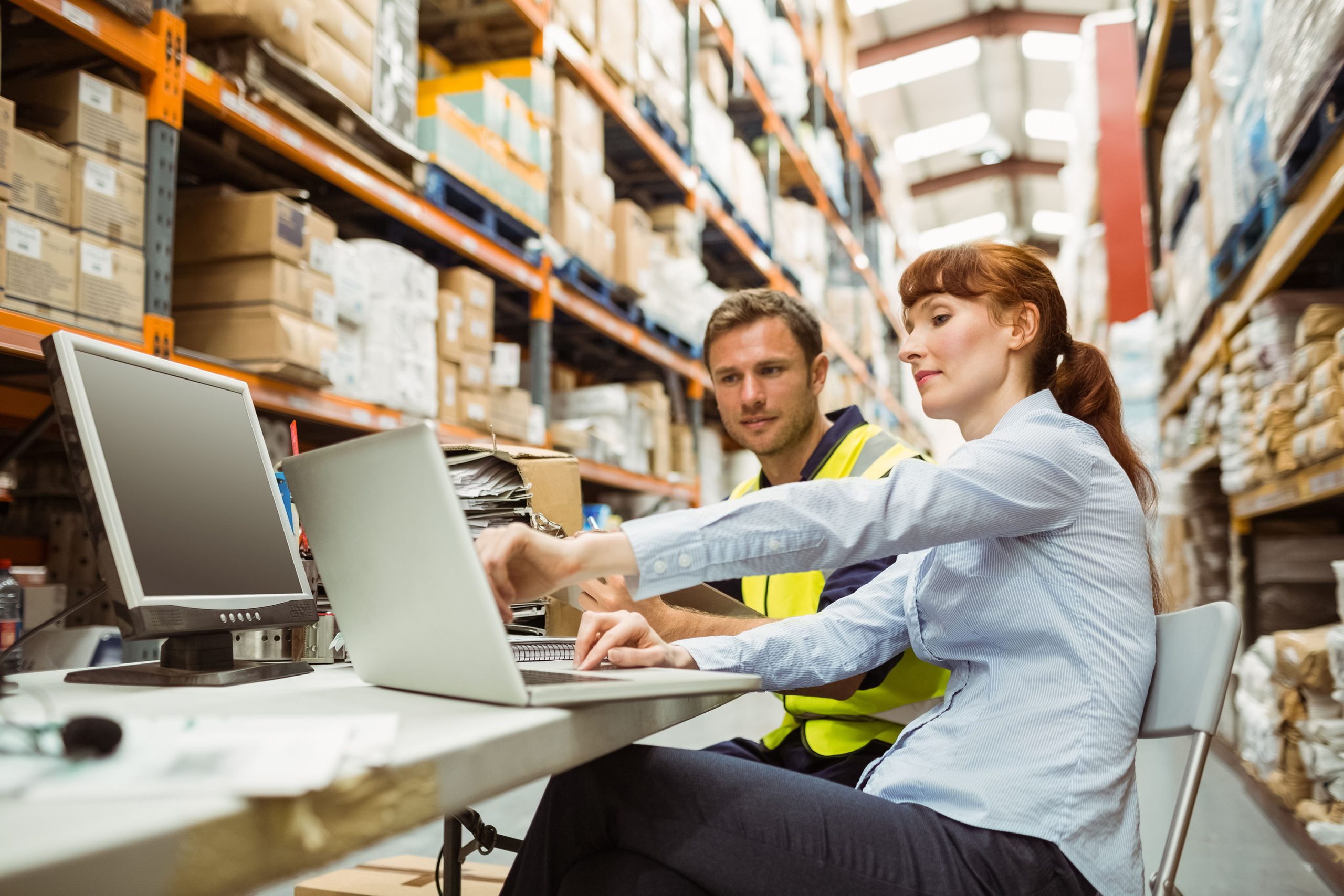 Warehouse worker and manager looking at Management Liability Insurance